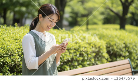 使用智慧型手機的年輕女子(戶外) 使用智慧型手機的年輕女子(戶外) 126473579