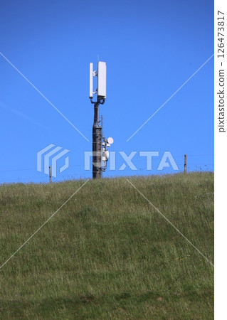 A tall pole with a cell phone tower on top of it 126473817