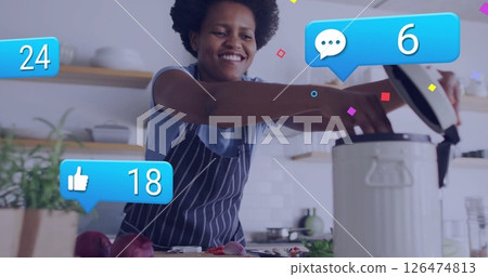 Cooking in kitchen, person receiving social media notifications over image 126474813