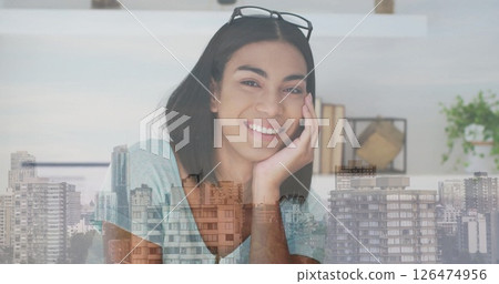 Smiling woman with glasses on head over cityscape image 126474956