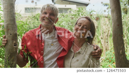Image of red spots over happy caucasian couple embracing in garden Image of red spots over happy caucasian couple embracing in garden 126475503