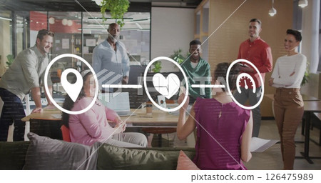 Image of media icons over diverse colleagues discussing work in office 126475989