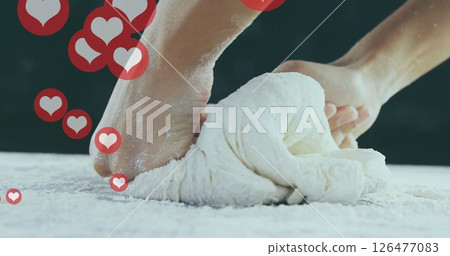 Kneading dough with heart icons image over hands on floured surface Kneading dough with heart icons image over hands on floured surface 126477083