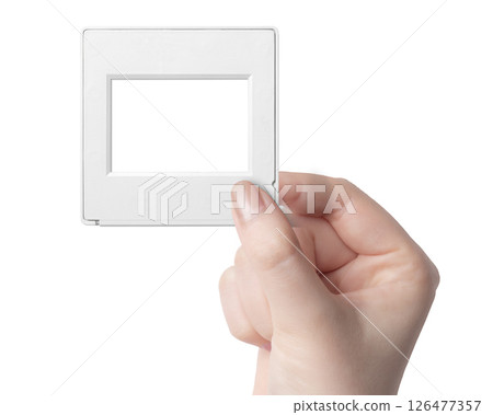 Woman's hand holding a 35mm film slide mount 126477357