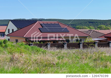 Family house with solar panels on the roof. Home photovoltaic power plant. Concept for industry and green cheaper electricity from renewable sources. Family house with solar panels on the roof. Home photovoltaic power plant. Concept for industry and green cheaper electricity from renewable sources. 126478199