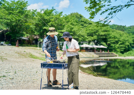 Men and women enjoying barbecue Men and women enjoying barbecue 126478440