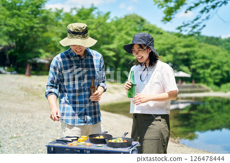 Men and women enjoying barbecue Men and women enjoying barbecue 126478444