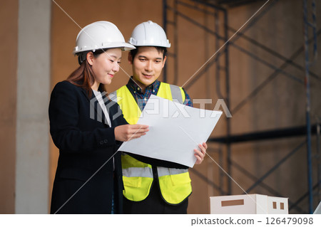 Engineering Team Collaborates on Blueprint Model in Corporate Office. Engineering Team Collaborates on Blueprint Model in Corporate Office. 126479098