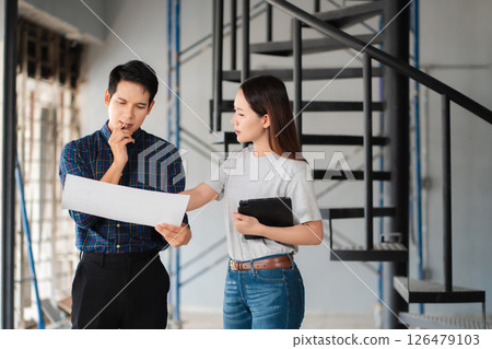 Engineering Team Collaborates on Blueprint Model in Corporate Office. 126479103