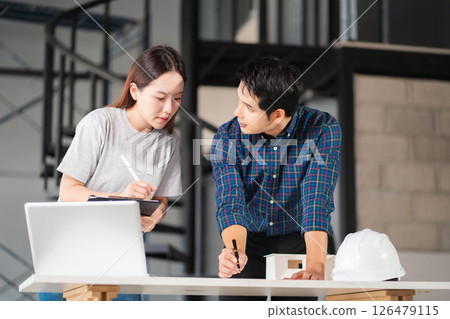 Engineer teams meeting working together wear worker helmets hardhat on construction site. Asian industry professional team. 126479115