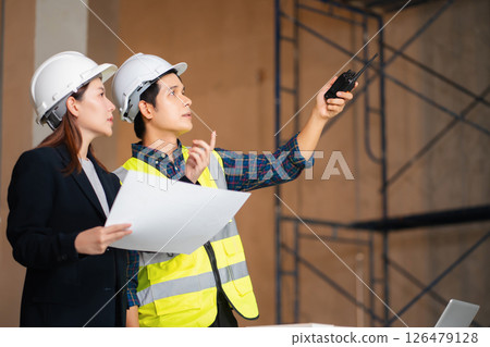 Businessman working as a team discussing data working and tablet, laptop with on on architectural project at construction site. 126479128