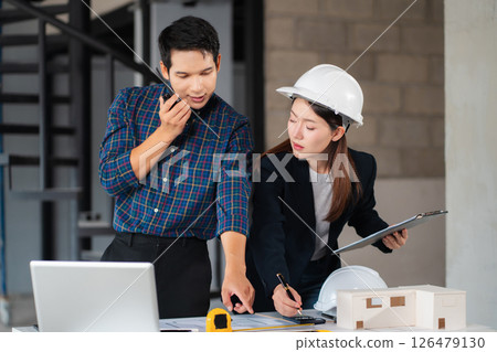 Businessman working as a team discussing data working and tablet, laptop with on on architectural project at construction site. Businessman working as a team discussing data working and tablet, laptop with on on architectural project at construction site. 126479130