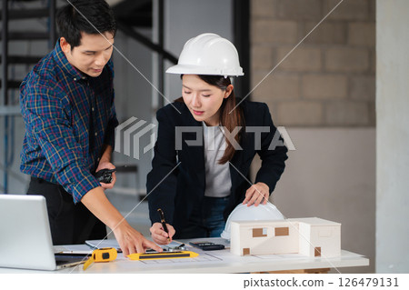 Businessman working as a team discussing data working and tablet, laptop with on on architectural project at construction site. Businessman working as a team discussing data working and tablet, laptop with on on architectural project at construction site. 126479131