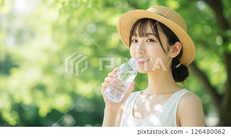 A young woman drinking water to prevent heat stroke 126480062