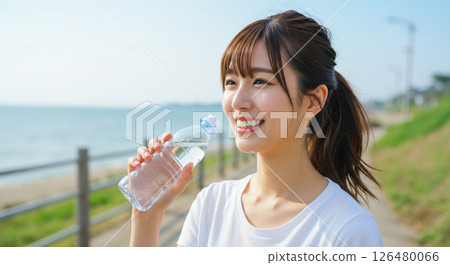 A young woman drinking water to prevent heat stroke A young woman drinking water to prevent heat stroke 126480066