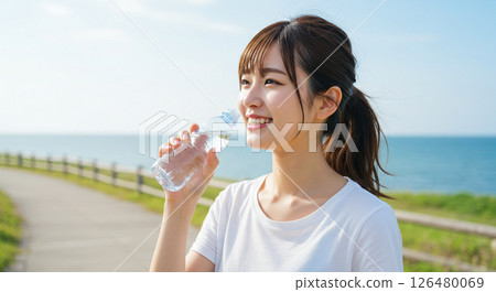 A young woman drinking water to prevent heat stroke 126480069