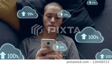 Image of cloud icons over biracial man using smartphone Image of cloud icons over biracial man using smartphone 126480513