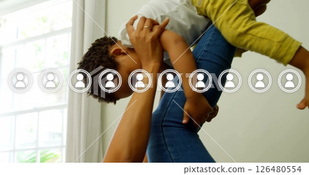 Holding child and smiling, woman with social network image overlaid 126480554