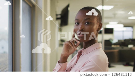 Image of digital cloud icons with arrows over african american businesswoman in office Image of digital cloud icons with arrows over african american businesswoman in office 126481113