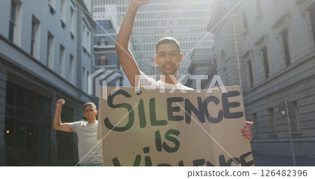 Two biracial men on a protest march holding placards raising hands and shouting 126482396