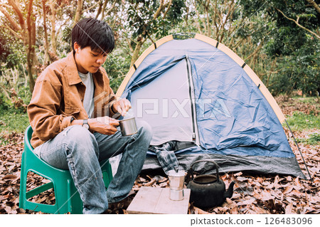 Happy asian lesbian holding hot espresso stainless steel with Italian Moka coffee pot drinking in a forest on vacation, traveler outdoor the tent happy single picnic camping on the morning Happy asian lesbian holding hot espresso stainless steel with Italian Moka coffee pot drinking in a forest on vacation, traveler outdoor the tent happy single picnic camping on the morning 126483096