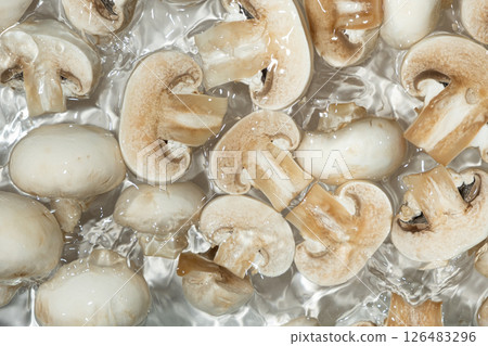 Raw White Mushrooms Champignons Close-Up Splash in a Water Top View Raw White Mushrooms Champignons Close-Up Splash in a Water Top View 126483296