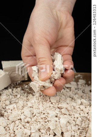 Crumbling Moist Yeast Block by Hand Close-Up. 126483313