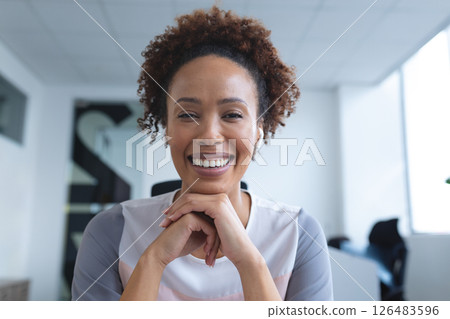 Smiling confidently, African American woman feeling accomplished at office desk Smiling confidently, African American woman feeling accomplished at office desk 126483596