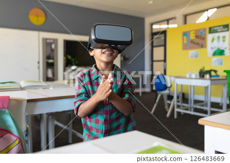 In school, young boy using VR headset and clapping hands in classroom 126483669