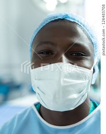 African American healthcare worker wearing mask and scrubs smiling in hospital 126483708