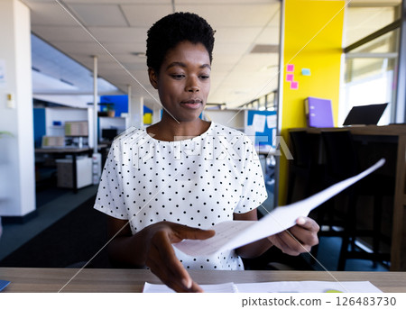 Reviewing documents at office desk, businesswoman concentrating on paperwork 126483730