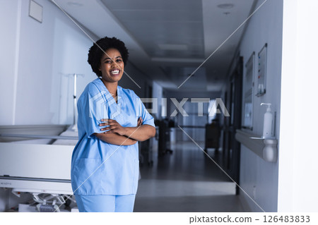 African American nurse in scrubs smiling confidently in hospital corridor, copy space African American nurse in scrubs smiling confidently in hospital corridor, copy space 126483833