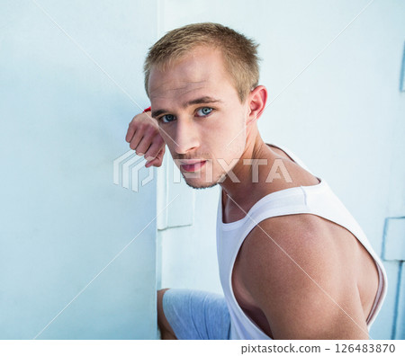 Young man in white tank top preparing for parkour challenge in urban setting Young man in white tank top preparing for parkour challenge in urban setting 126483870