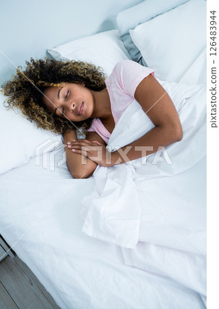 Peacefully sleeping woman resting comfortably in cozy bed at home Peacefully sleeping woman resting comfortably in cozy bed at home 126483944