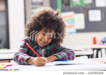 In school, happy child writing in notebook, enjoying classroom activities 126484266