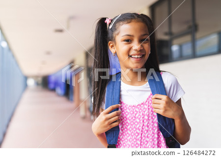 Smiling girl with backpack standing in school hallway, ready for class, copy space Smiling girl with backpack standing in school hallway, ready for class, copy space 126484272