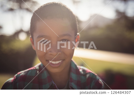 Smiling boy outdoors enjoying sunny day in casual plaid shirt 126484307