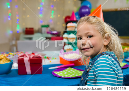 Smiling child at birthday party with colorful decorations and gift boxes, copy space 126484339