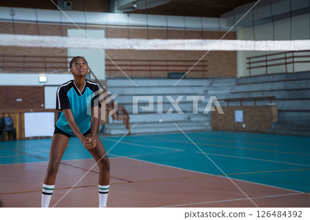 In school gymnasium, athlete preparing to receive volleyball with focus, copy space 126484392