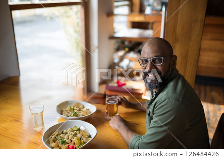 Smiling man enjoying Mexican food and beer at cozy restaurant table, copy space Smiling man enjoying Mexican food and beer at cozy restaurant table, copy space 126484426