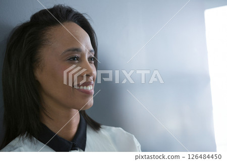 Smiling woman in business attire looking confidently at office wall, copy space Smiling woman in business attire looking confidently at office wall, copy space 126484450