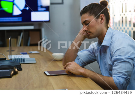 Businessman using tablet at office desk, focusing on digital presentation, copy space Businessman using tablet at office desk, focusing on digital presentation, copy space 126484459
