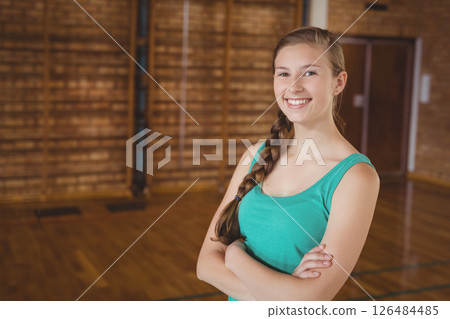 Standing confidently with arms crossed, woman in gym wearing sportswear, smiling, copy space 126484485