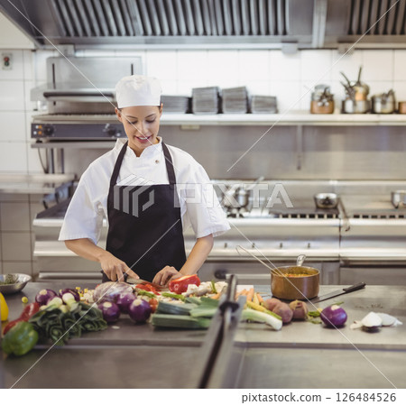 In professional kitchen, chef chopping vegetables, preparing meal with focus, copy space 126484526