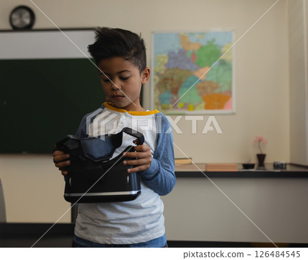 In school, young boy exploring virtual reality headset in classroom setting 126484545