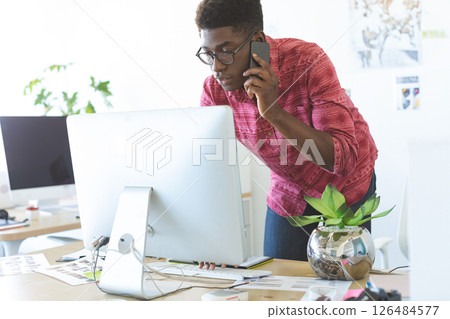 In office, professional multitasking using smartphone and computer efficiently In office, professional multitasking using smartphone and computer efficiently 126484577