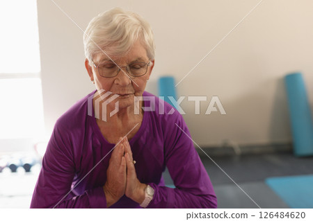 Senior woman practicing yoga with eyes closed, focusing on meditation and balance Senior woman practicing yoga with eyes closed, focusing on meditation and balance 126484620