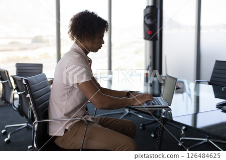 Business professional working on laptop in modern office conference room, copy space 126484625