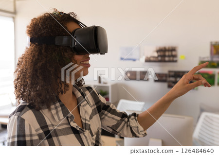 Woman using VR headset in office, interacting with virtual environment, copy space 126484640
