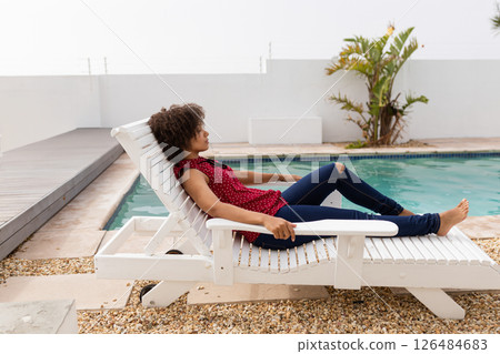 Relaxing by pool, woman lounging on chair enjoying sunny day at home, copy space Relaxing by pool, woman lounging on chair enjoying sunny day at home, copy space 126484683